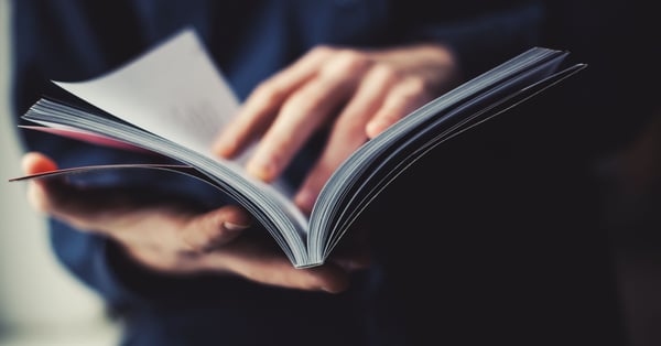 Hombre sostiene y lee revista internacional de finanzas