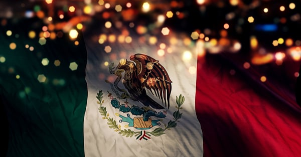 Bandera de México sobre fondo nocturno de ciudad 