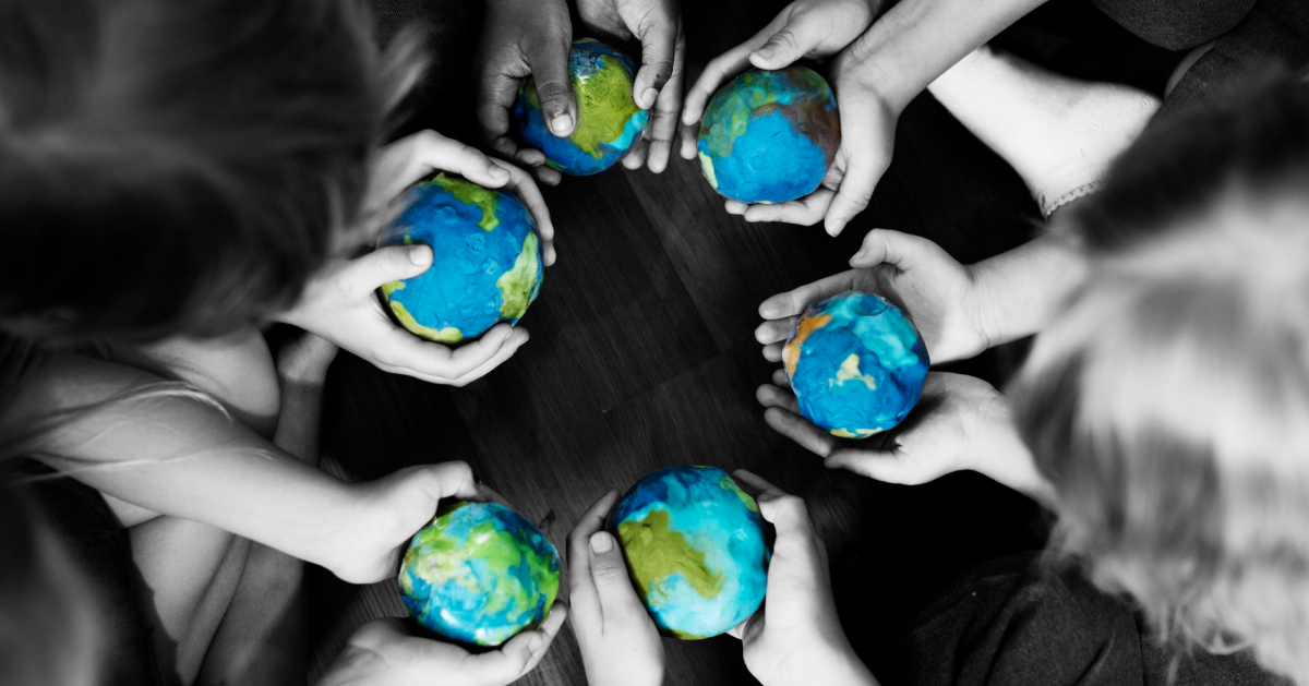 Niños sostienen globos terráqueos y representan derechos humanos