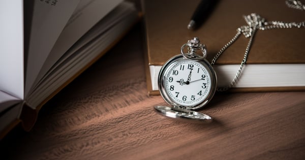 Reloj de manecillas sobre libros de derecho