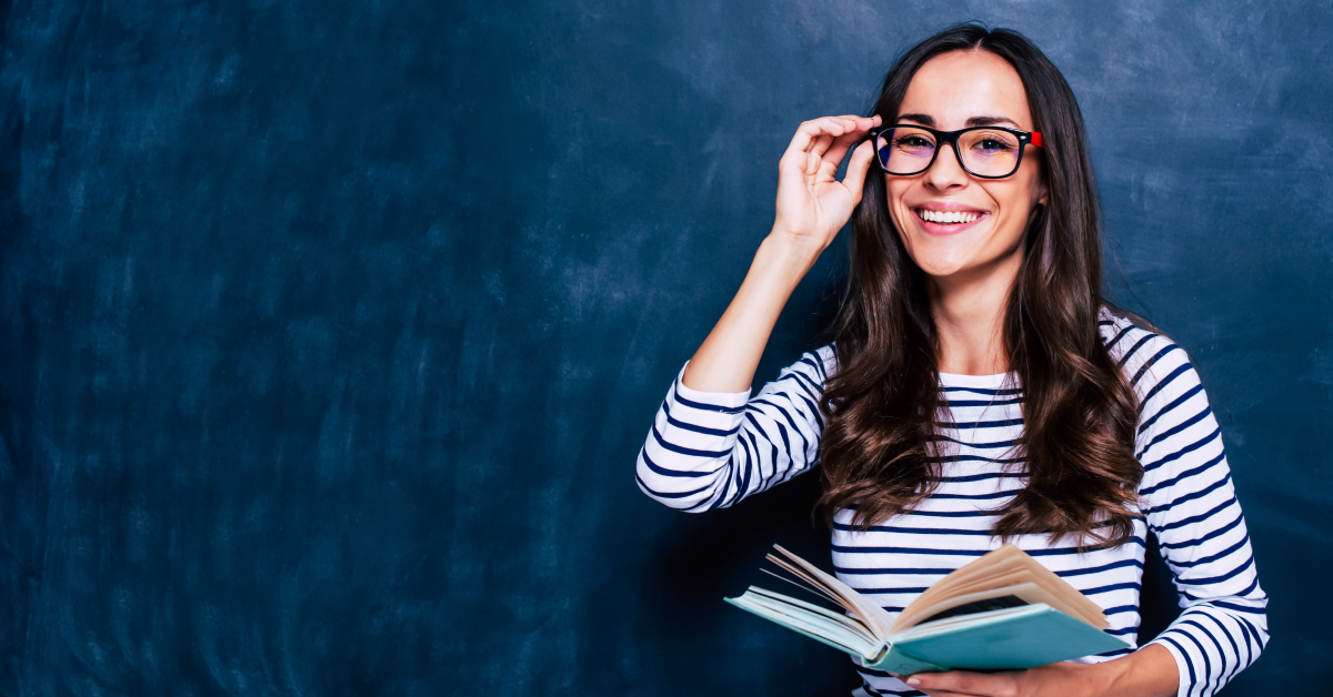Estudiante de pedagogía con lentes frente a pizarrón