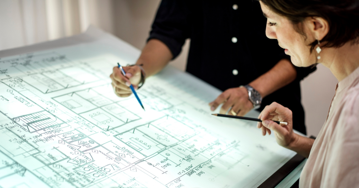 Maestros arquitectos diseñando plano para planta industrial
