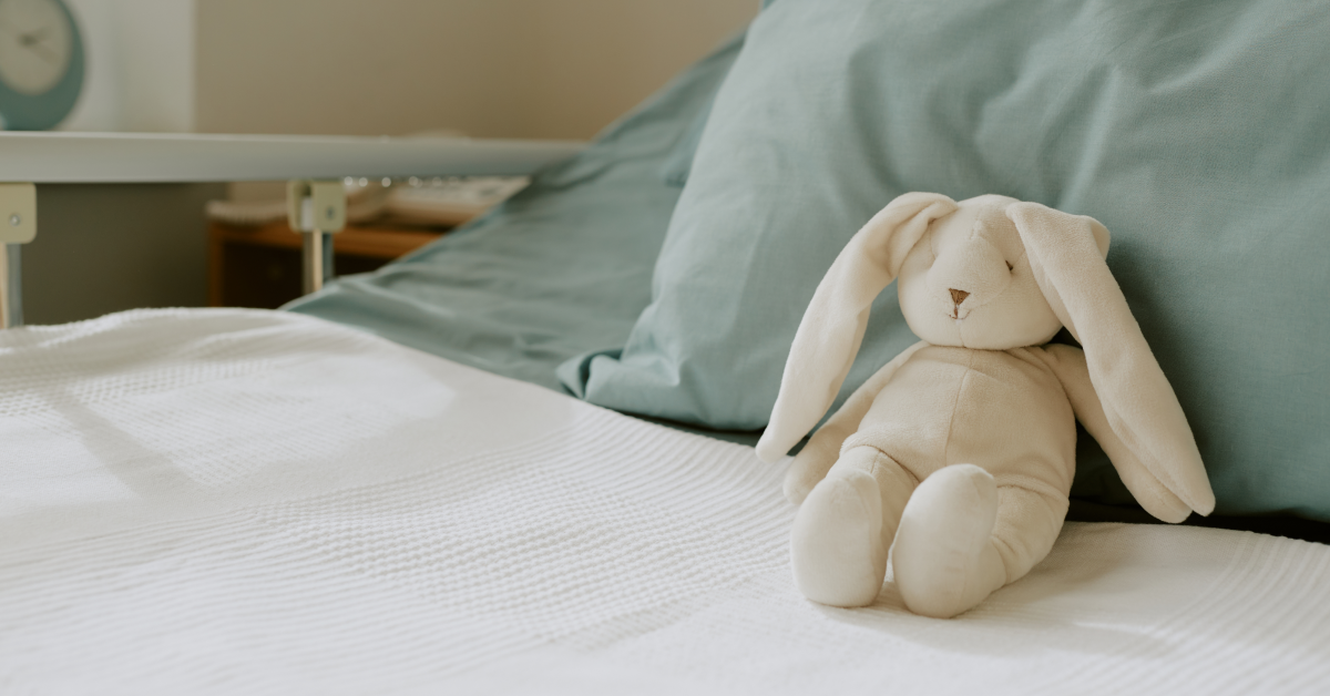 Conejo de peluche sobre almohada de hospital infantil