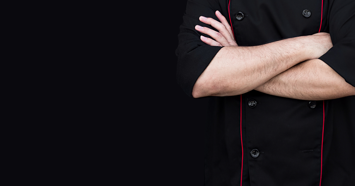 Chef ejecutivo cruzado de brazos con fondo negro