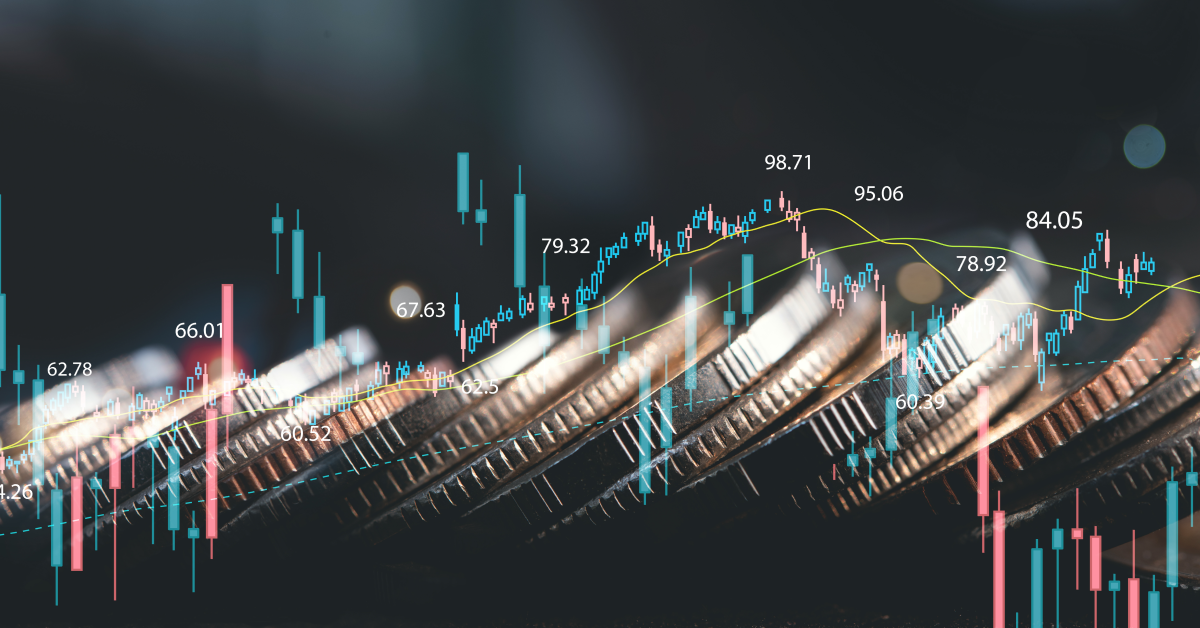 Monedas apiladas detrás de gráfico de velas