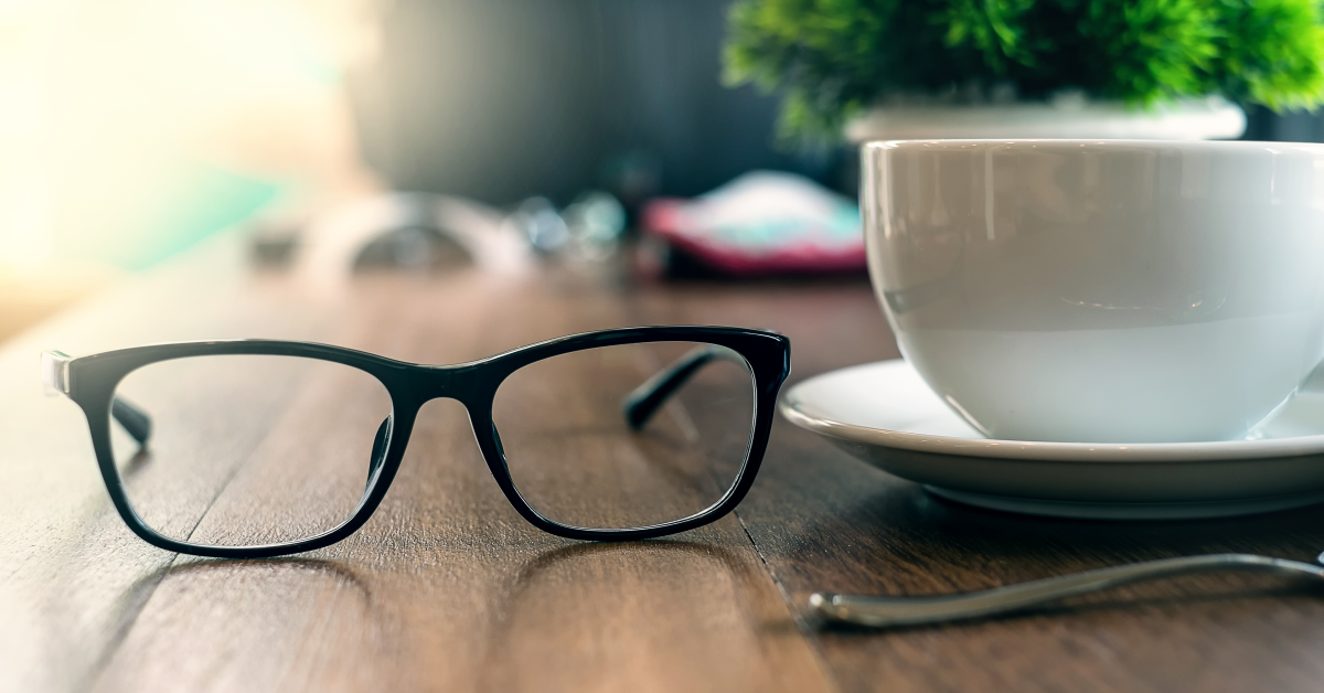Lentes de coordinador de eventos junto a taza de café