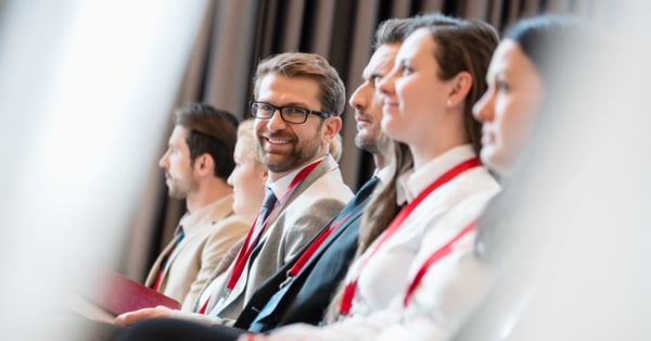 Hombre sonriente acude a evento empresarial concurrido