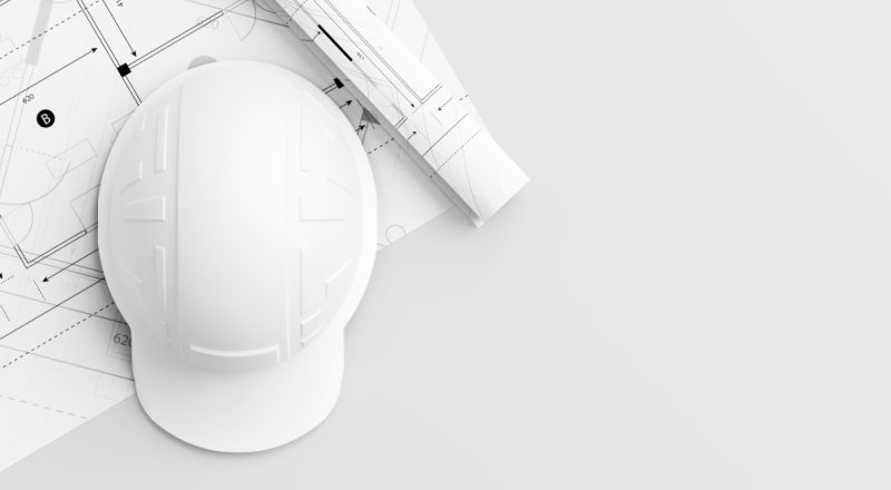 Casco de protección sobre plano de construcción