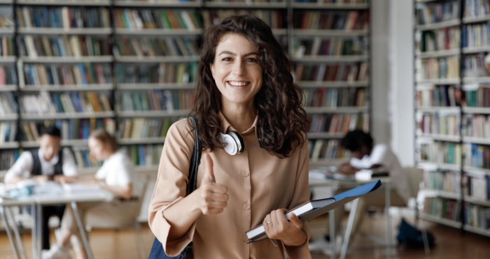 Estudiante de pedagogía alegre en biblioteca