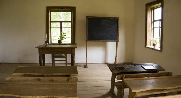 Salón de clases antiguo con butacas y pizarrón