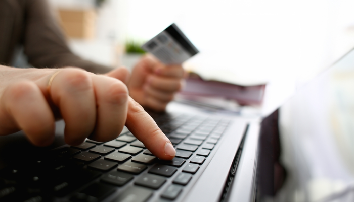 Persona cometiendo fraude financiero a través de computadora