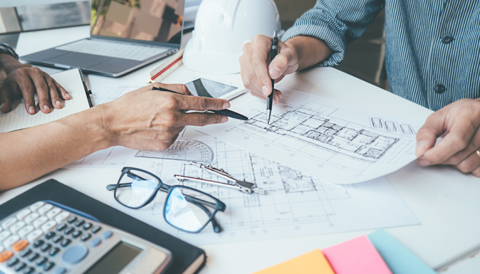 Diseñadores arquitectónicos trabajan en plano de construcción