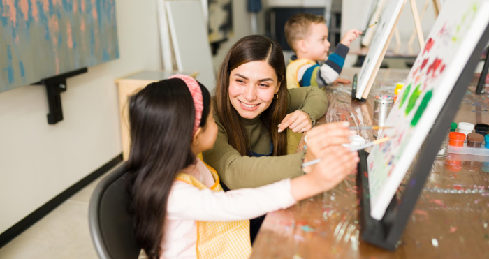 Docente de preescolar dando clases de arte en aula