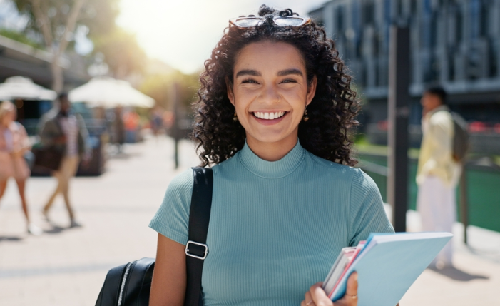 Estudiante de pedagogía sonriente afuera de su universidad