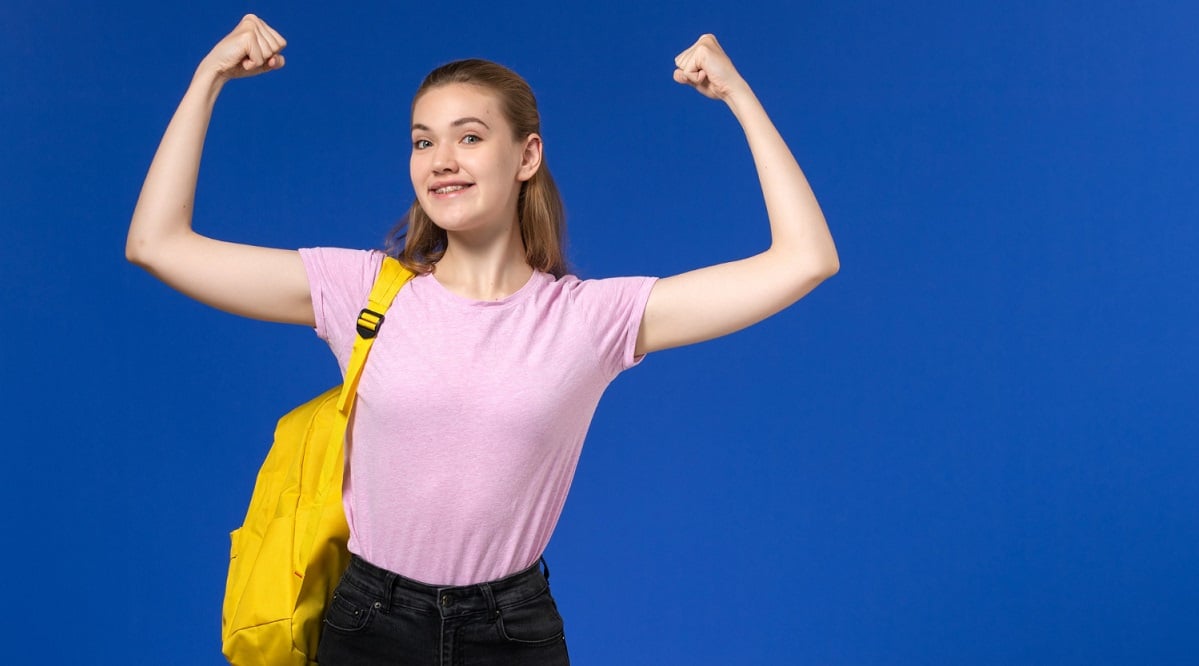front-view-female-student-pink-t-shirt-with-yellow-backpack-smiling-flexing-light-blue-wall