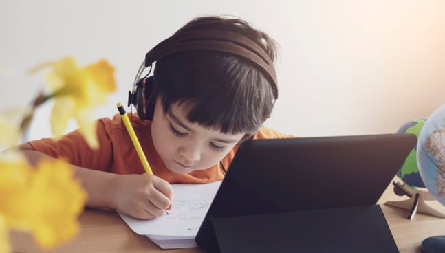 Niñoa hace su tarea con uso de tecnología