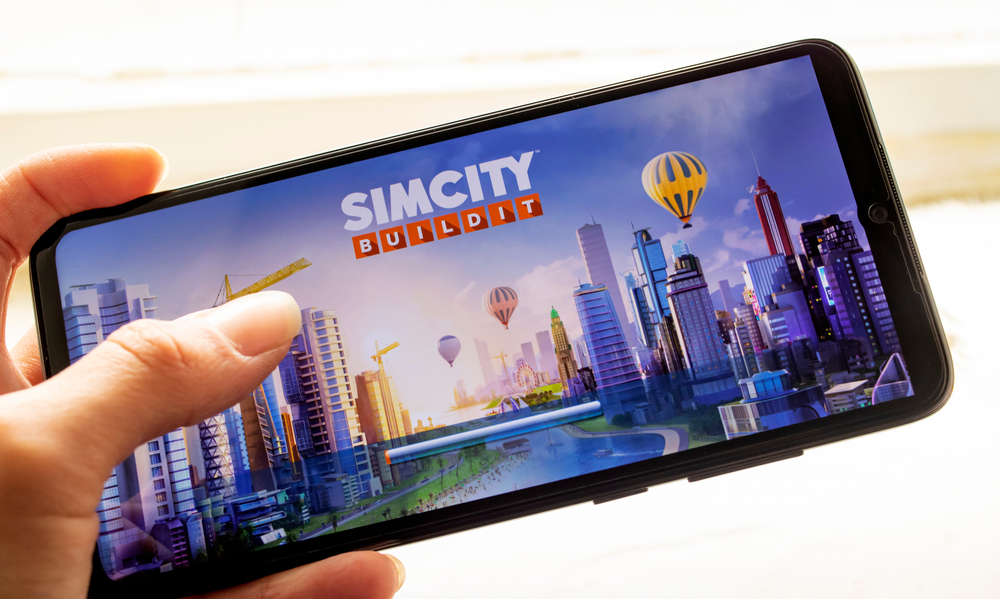 Celular que muestra juego de economía llamado Sim City