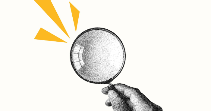 Mano y lupa con diseño de rayos amarillos