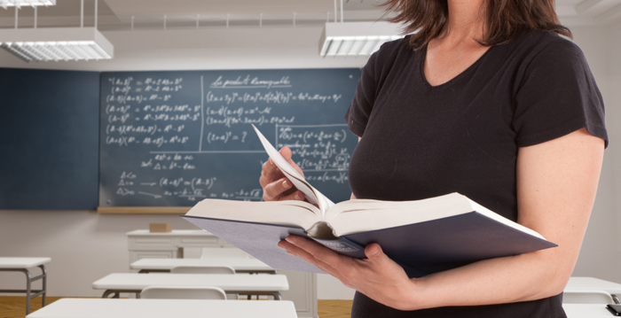 Pedagoga en salón de clases con pizarrón