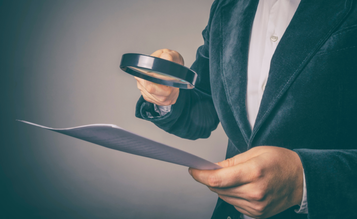 Auditor forense revisa documentos financieros en empresa