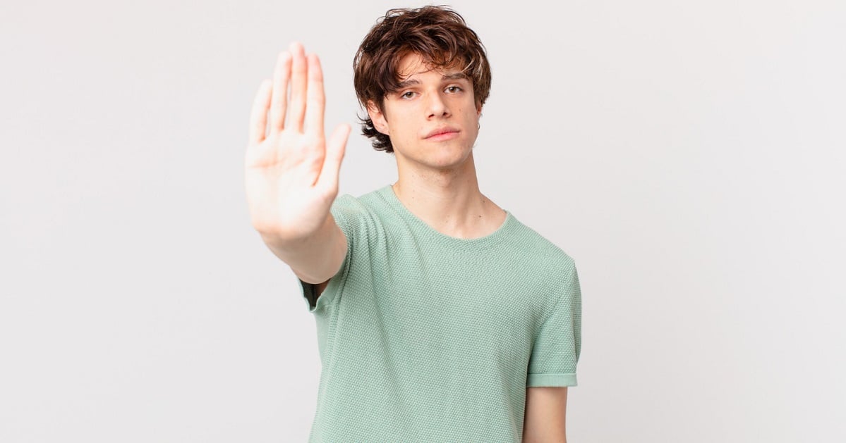 young-handsome-man-looking-serious-showing-open-palm-making-stop-gesture